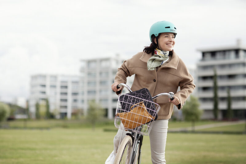nainen seisoo polkupyörän kanssa